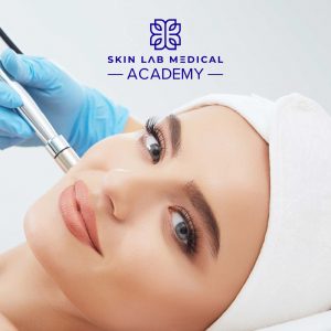 Smiling woman receiving a microdermabrasion facial treatment from a gloved professional at Skin Lab Medical Academy.